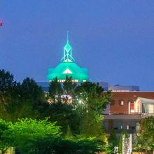 Johnson Center spier illuminated green on the Fairfax Virginia campus of George Mason University